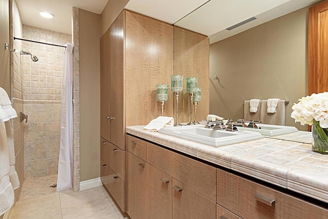 bathroom with vanity, tile patterned flooring, and curtained shower