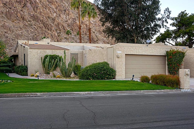 view of front of home with a front lawn and a garage