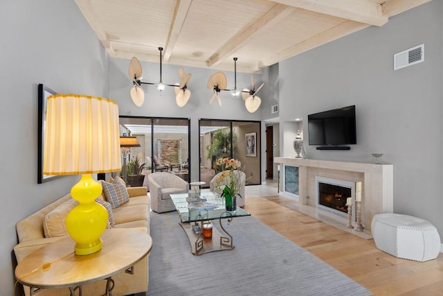 living room with beam ceiling, ceiling fan, wood ceiling, and wood-type flooring