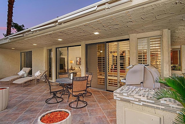 patio terrace at dusk with an outdoor kitchen