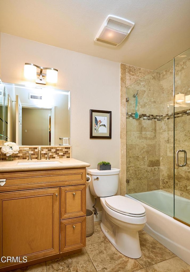 full bathroom with vanity, tasteful backsplash, combined bath / shower with glass door, and toilet