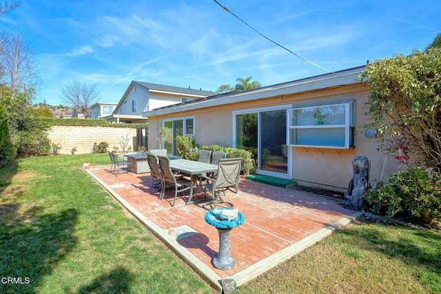 back of property with a yard and a patio