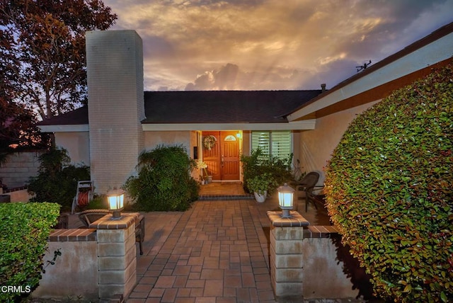 exterior entry at dusk featuring a patio area