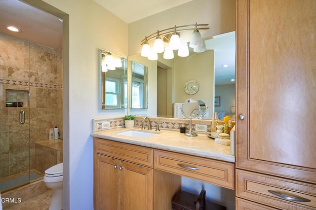 bathroom featuring tile patterned floors, vanity, toilet, and a shower with shower door