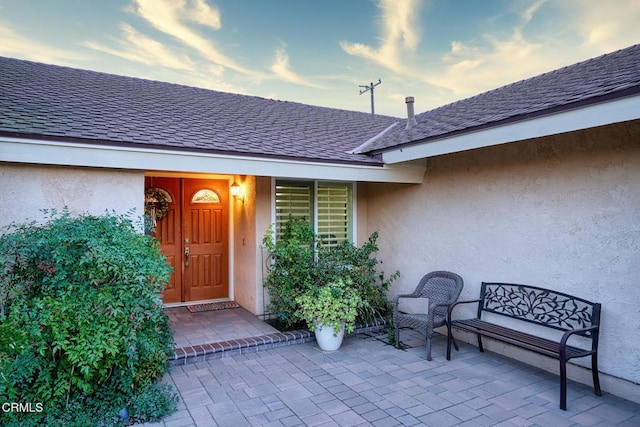 exterior entry at dusk featuring a patio