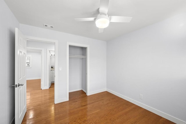 unfurnished bedroom featuring ceiling fan, a closet, and hardwood / wood-style flooring