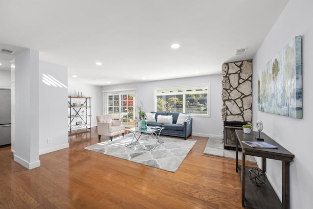 living room with wood-type flooring and a fireplace