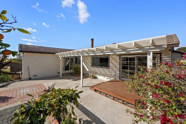 back of house with a deck, a patio, and a pergola