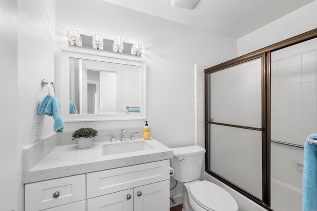 full bathroom with toilet, bath / shower combo with glass door, and vanity