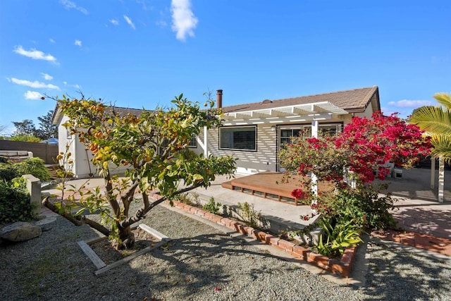 back of property featuring a pergola and a deck