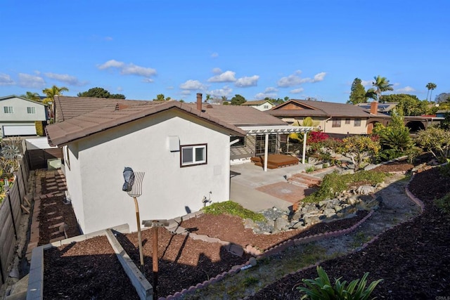 rear view of house featuring a pergola and a patio area