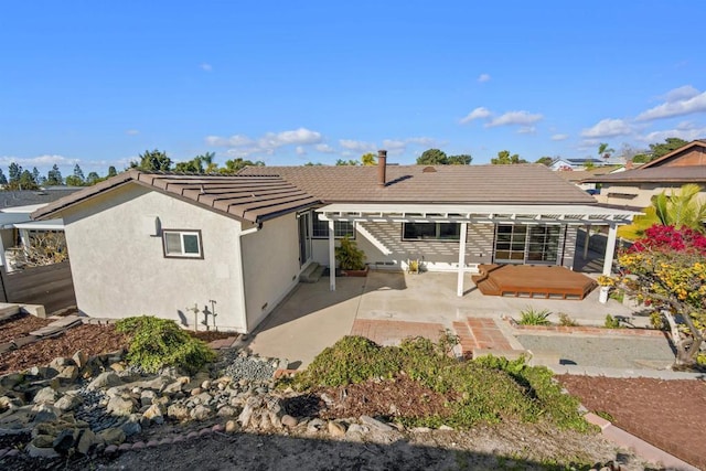 back of house featuring a hot tub and a patio