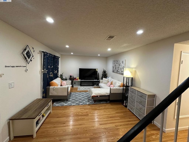 living room with light hardwood / wood-style flooring and a textured ceiling