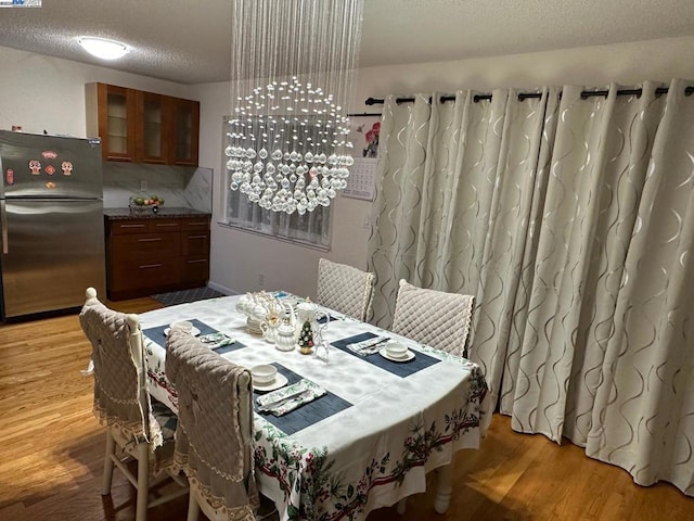 dining area featuring hardwood / wood-style flooring and a textured ceiling