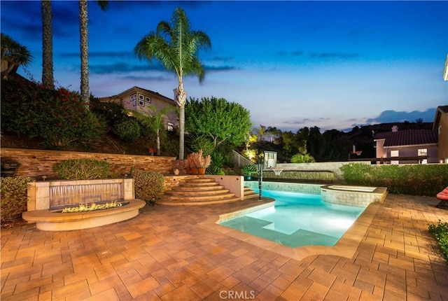 view of pool featuring a patio, fence, and a pool with connected hot tub