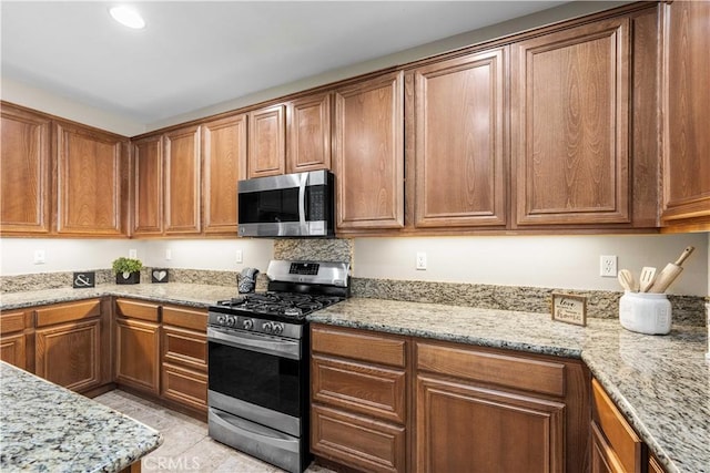 kitchen with light stone countertops and appliances with stainless steel finishes