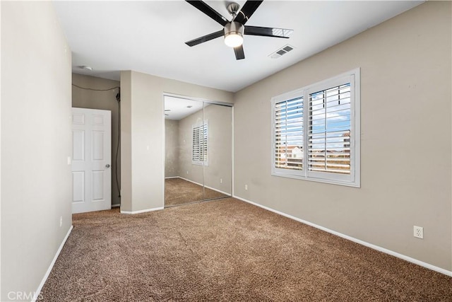 unfurnished bedroom with ceiling fan, a closet, and carpet flooring