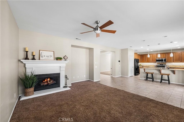 unfurnished living room featuring ceiling fan and light tile patterned flooring