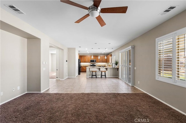 unfurnished living room with ceiling fan and light colored carpet