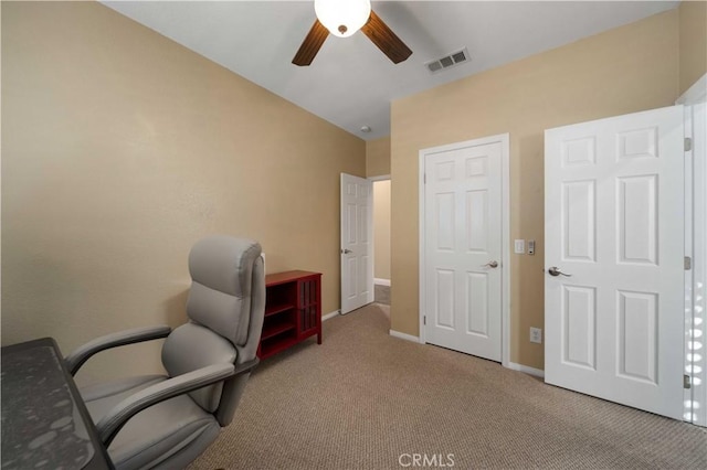 carpeted office space with ceiling fan