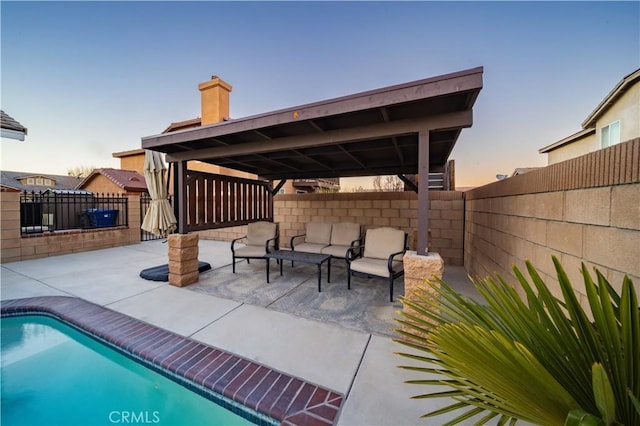 pool at dusk with a patio area