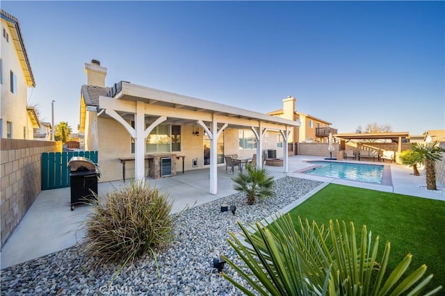 back of property featuring a fenced in pool, a patio area, and a yard