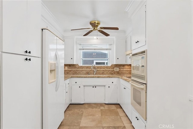 kitchen featuring white appliances, white cabinetry, tasteful backsplash, sink, and ceiling fan