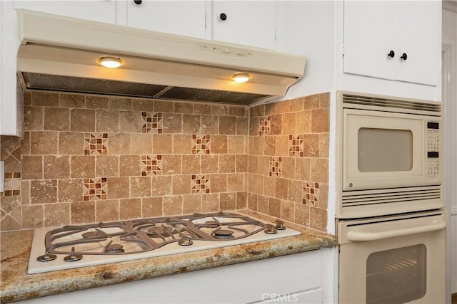 kitchen with white cabinetry, white appliances, and tasteful backsplash