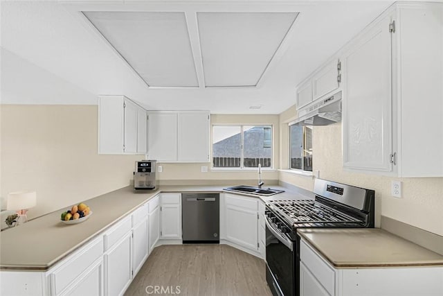 kitchen with white cabinets, sink, stainless steel appliances, and light hardwood / wood-style floors