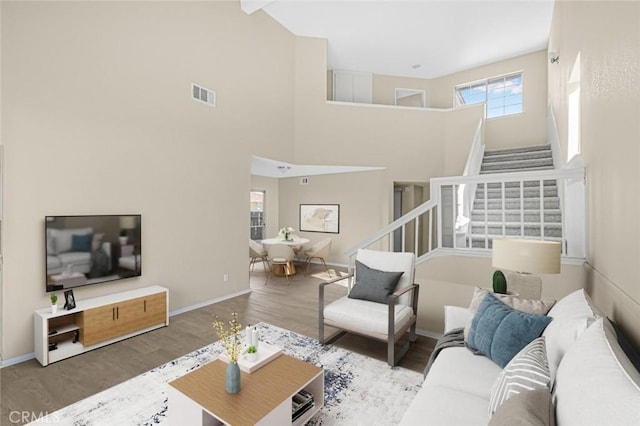 living room with hardwood / wood-style floors and a high ceiling