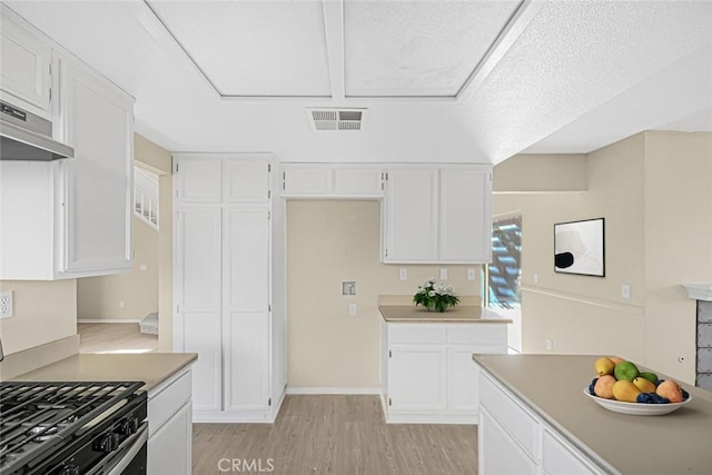 kitchen with a textured ceiling, white cabinetry, range with gas cooktop, and light hardwood / wood-style flooring