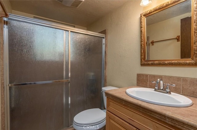 bathroom featuring toilet, tasteful backsplash, an enclosed shower, a textured ceiling, and vanity