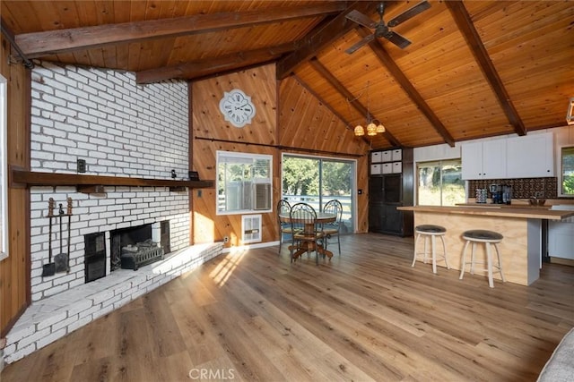 unfurnished living room with plenty of natural light, wooden ceiling, beam ceiling, and a fireplace