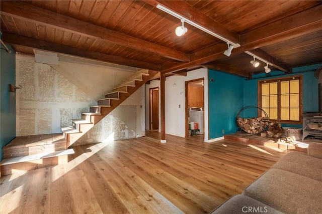 unfurnished living room featuring beam ceiling, light wood-type flooring, wooden ceiling, and rail lighting