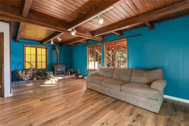 living room featuring wood-type flooring, rail lighting, a wood stove, wooden ceiling, and beam ceiling