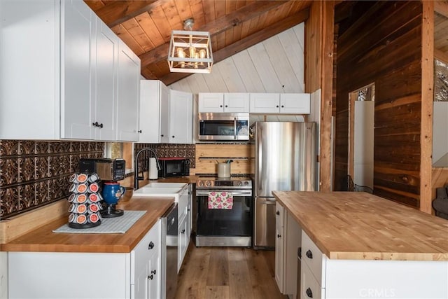 kitchen featuring wooden ceiling, white cabinets, stainless steel appliances, and wooden counters