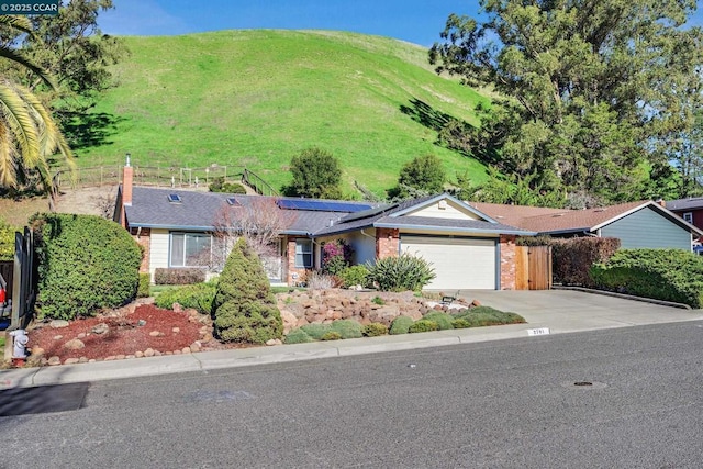 single story home featuring a garage and solar panels