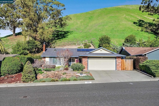 ranch-style house featuring solar panels and a garage