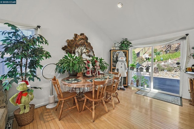 dining area with lofted ceiling and light wood-type flooring