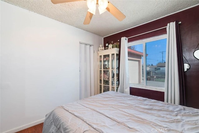 bedroom featuring a textured ceiling, ceiling fan, and wood-type flooring