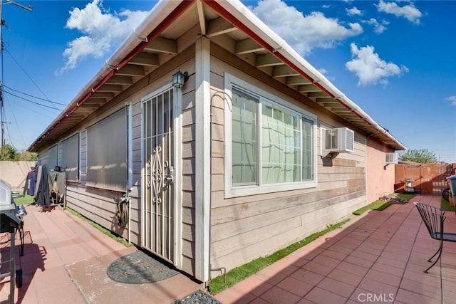 view of side of property featuring cooling unit and a patio area