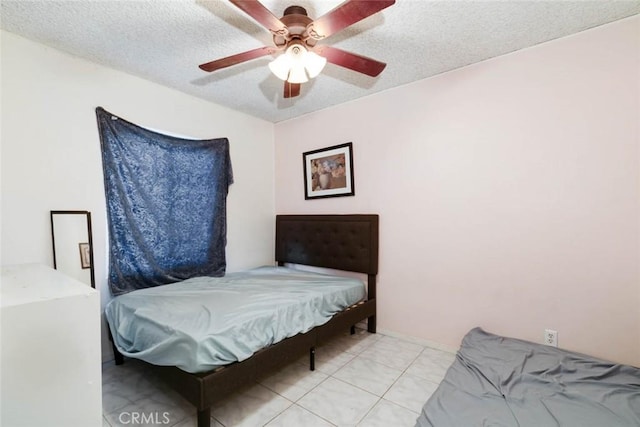 tiled bedroom with a textured ceiling and ceiling fan