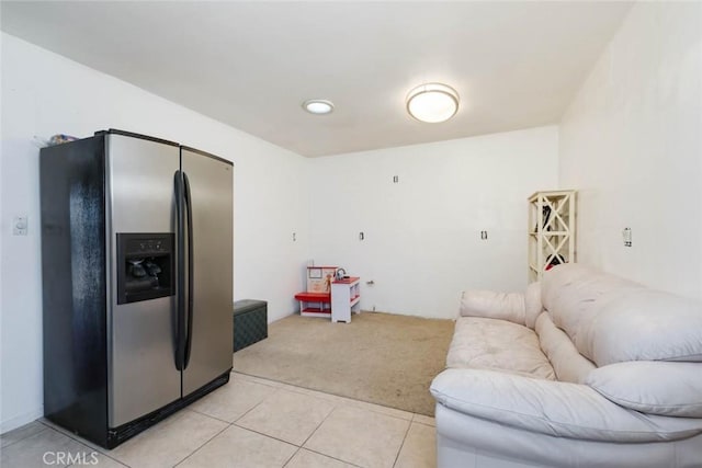 kitchen with light tile patterned floors and stainless steel fridge