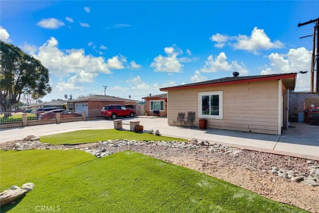 back of property with a patio area and a lawn