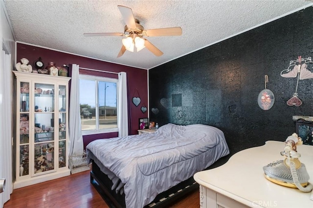 bedroom with ceiling fan, dark hardwood / wood-style flooring, and a textured ceiling