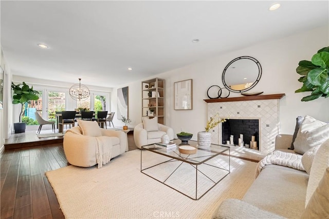 living room featuring a fireplace, a notable chandelier, and light hardwood / wood-style flooring