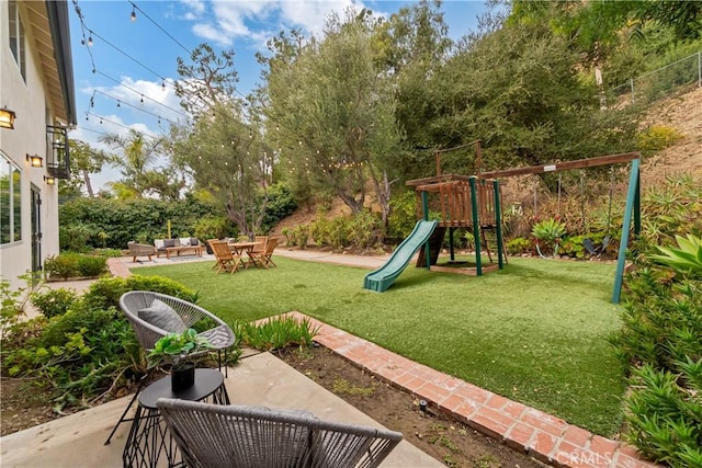 view of play area featuring a patio area, an outdoor living space, and a lawn