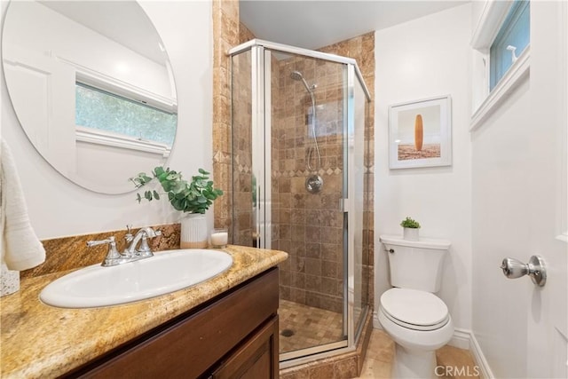 bathroom with walk in shower, vanity, tile patterned flooring, and toilet