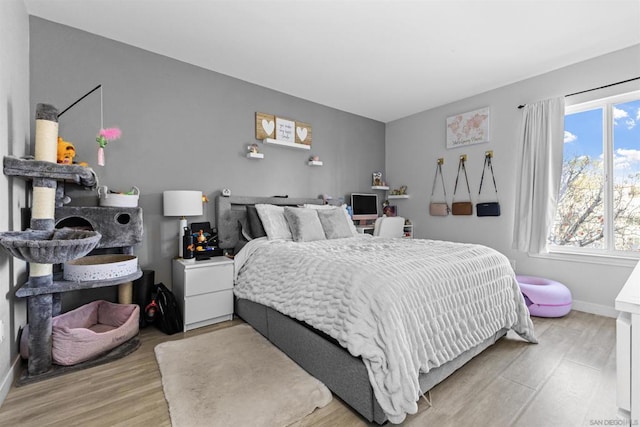 bedroom featuring multiple windows and light hardwood / wood-style floors