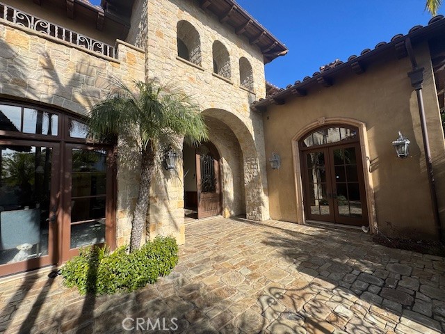 view of exterior entry featuring a patio area and french doors